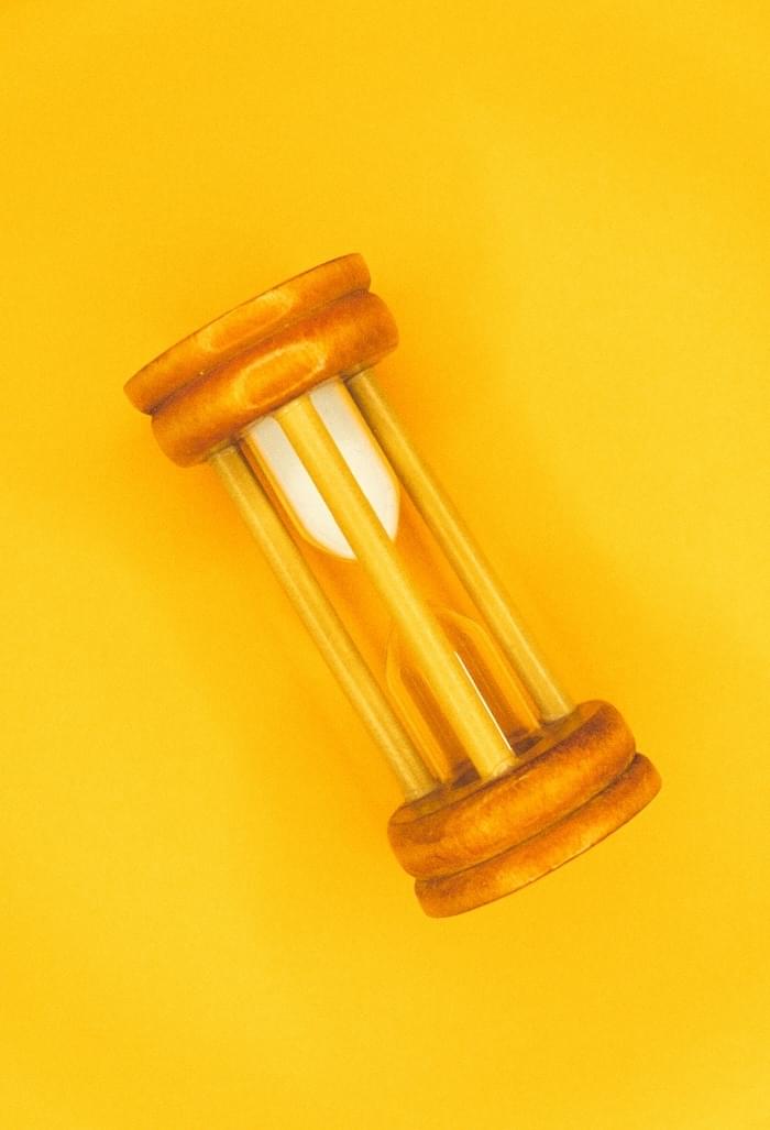 Small hourglass on yellow background suggests time is running out and creating stress for preachers
